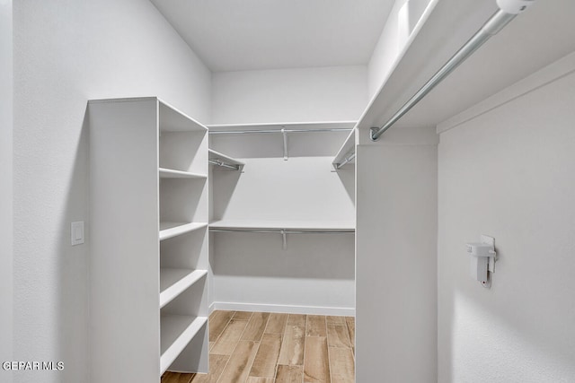 walk in closet featuring wood finish floors