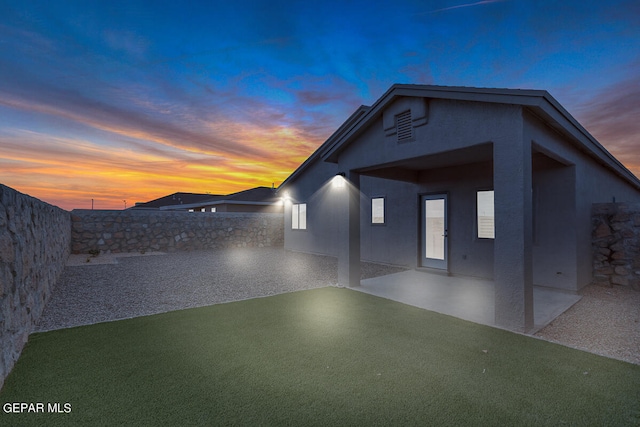 exterior space with stucco siding, a fenced backyard, and a patio