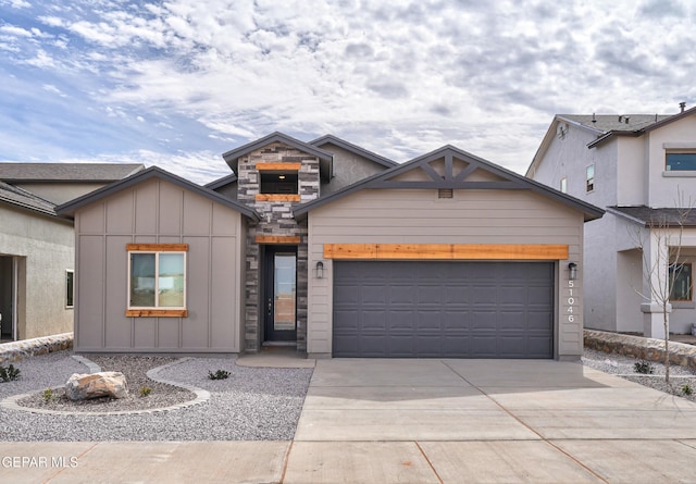 view of front facade with a garage, stone siding, board and batten siding, and concrete driveway