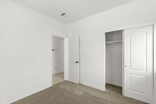 unfurnished bedroom featuring carpet flooring and a closet