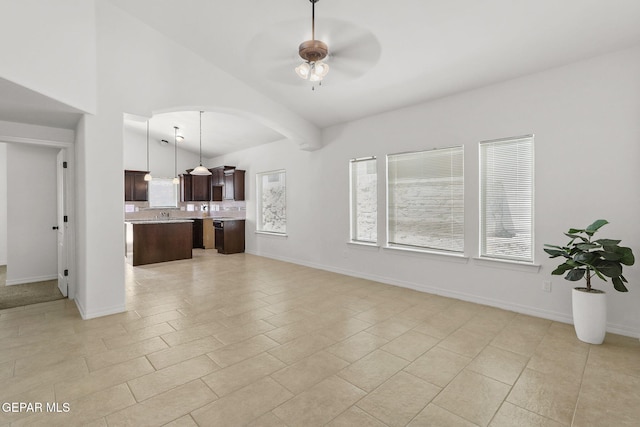 tiled living room with ceiling fan and vaulted ceiling