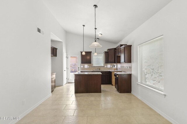 kitchen with high vaulted ceiling, tasteful backsplash, decorative light fixtures, a kitchen island, and dark brown cabinets