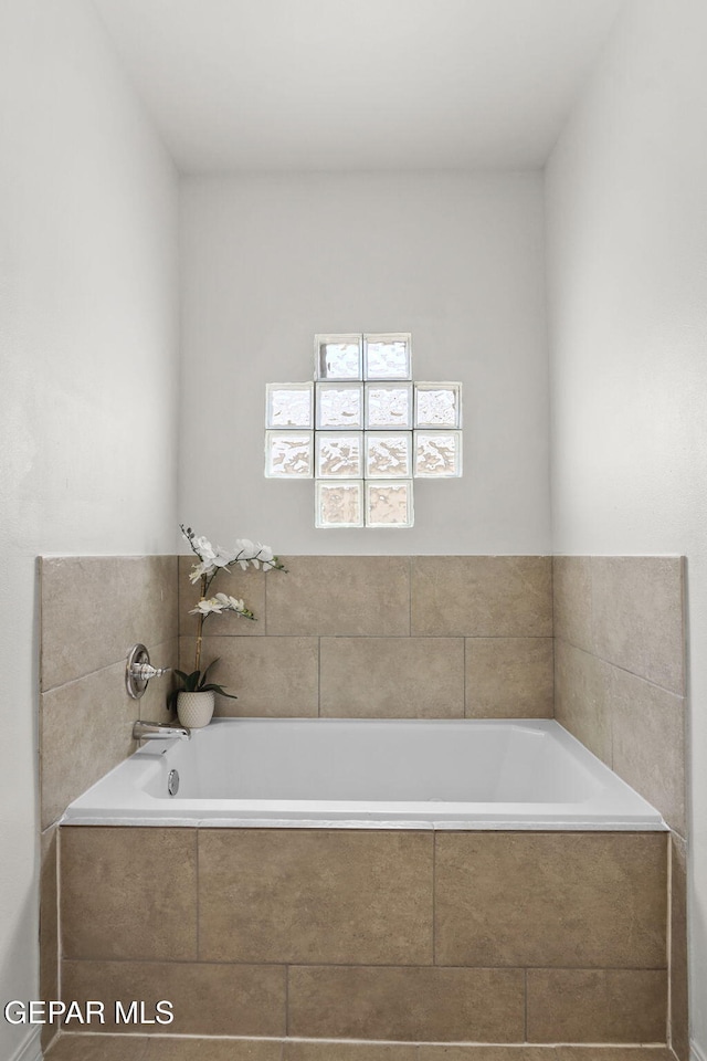 bathroom with a relaxing tiled tub