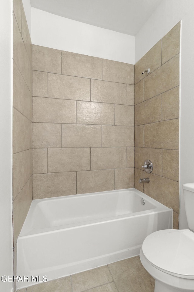 bathroom with tile patterned floors, tiled shower / bath, and toilet