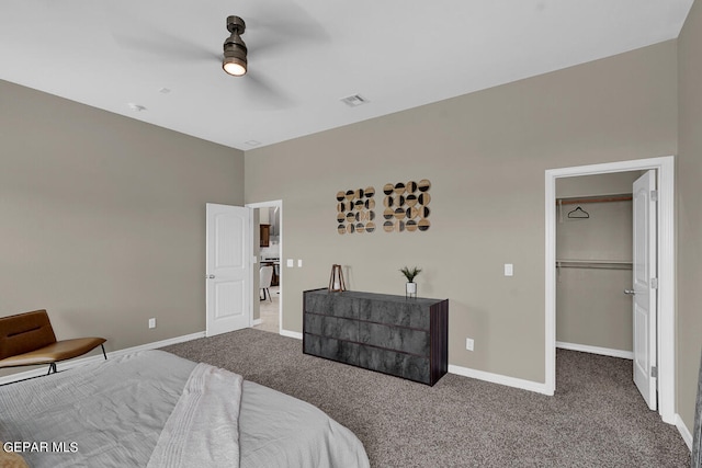 carpeted bedroom with ceiling fan, a closet, and a spacious closet