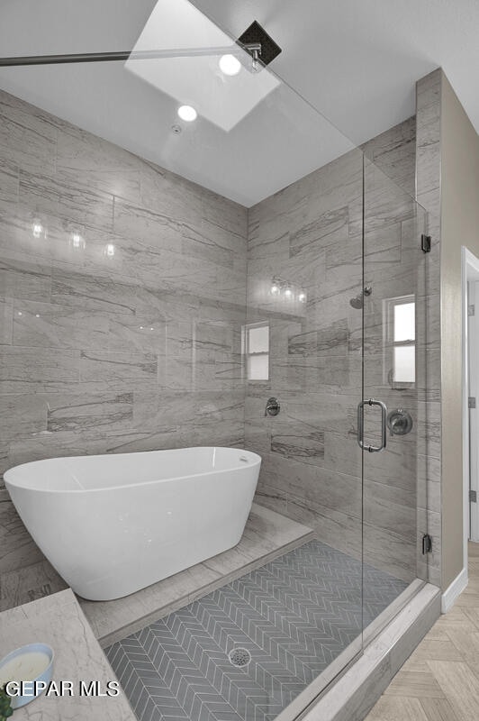 bathroom with independent shower and bath, tile floors, and tile walls