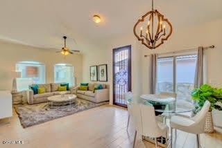 living room featuring ceiling fan with notable chandelier