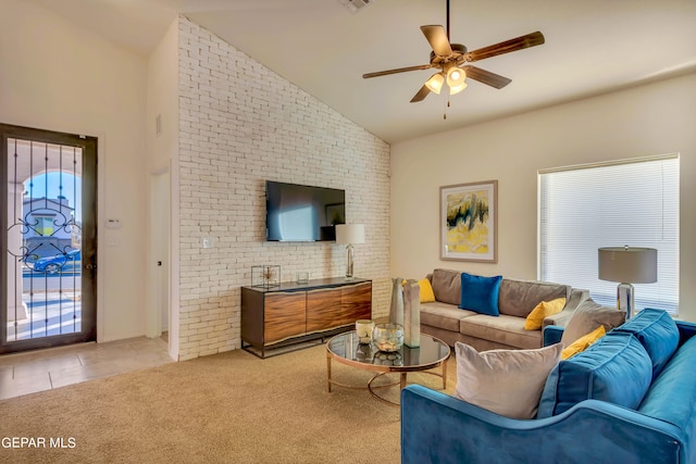 tiled living room with brick wall, ceiling fan, and vaulted ceiling