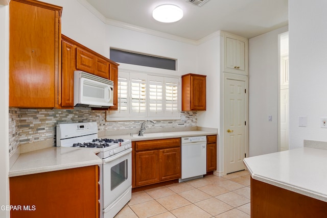 kitchen featuring crown molding, white appliances, sink, and tasteful backsplash