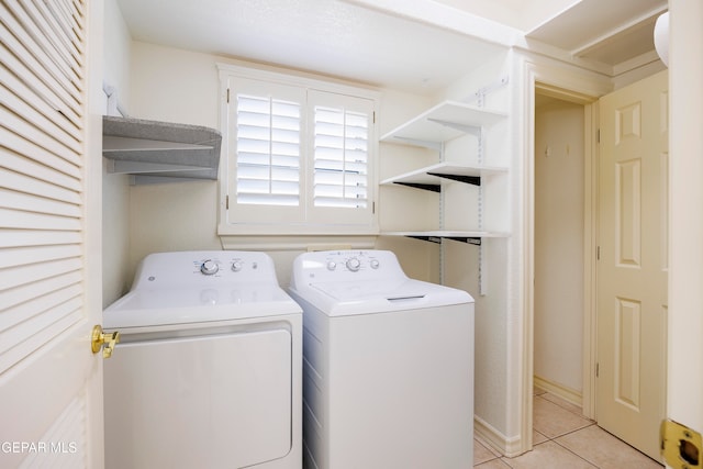 clothes washing area with light tile patterned floors and separate washer and dryer