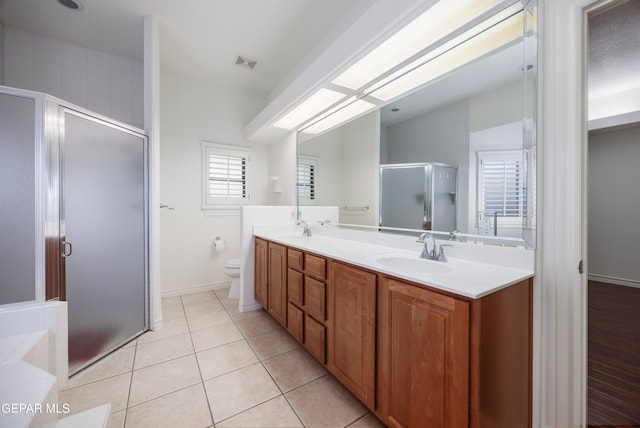 bathroom featuring tile patterned floors, toilet, vanity, and walk in shower