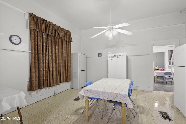 dining room featuring lofted ceiling, ceiling fan, and light tile floors