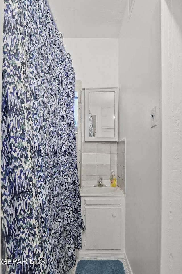 bathroom featuring tile walls, tasteful backsplash, and vanity