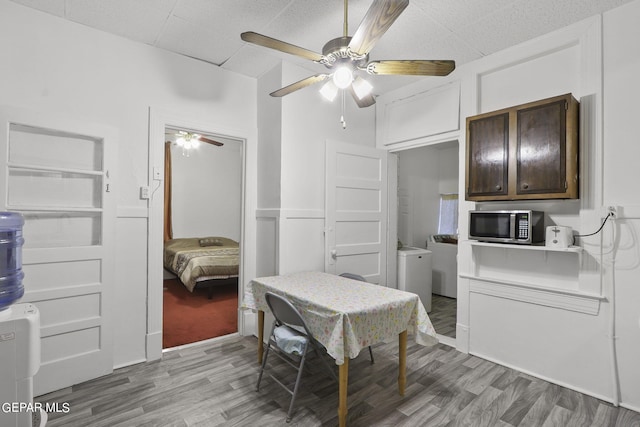 dining room featuring washer / clothes dryer, ceiling fan, and hardwood / wood-style flooring