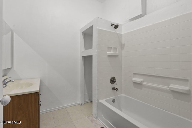 bathroom featuring tiled shower / bath, tile flooring, and vanity