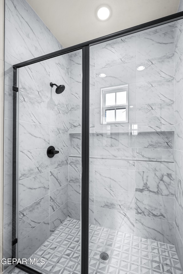 bathroom featuring a shower with shower door