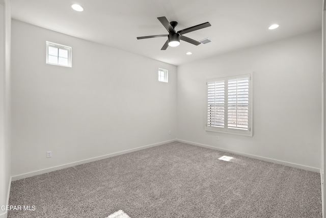 carpeted spare room featuring ceiling fan and plenty of natural light