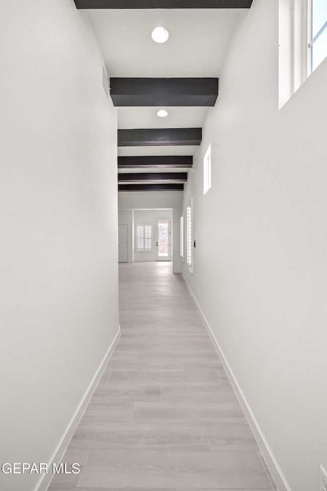 hall with light hardwood / wood-style flooring and beam ceiling