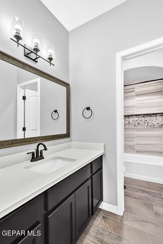 13357 Highworth Dr, El Paso, TX 79928 - bathroom featuring shower / bath combination, vanity, and wood-type flooring