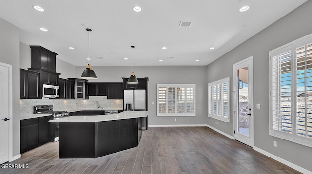 13357 Highworth Dr, El Paso, TX 79928 - kitchen featuring decorative backsplash, appliances with stainless steel finishes, pendant lighting, dark hardwood / wood-style floors, and a kitchen island