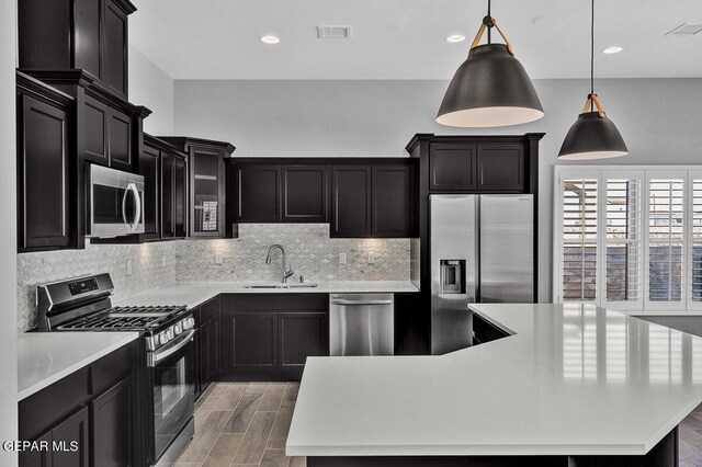 13357 Highworth Dr, El Paso, TX 79928 - kitchen with sink, hanging light fixtures, appliances with stainless steel finishes, a kitchen island, and light wood-type flooring