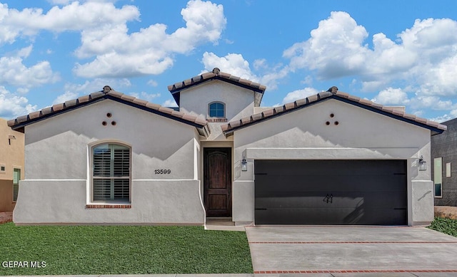 mediterranean / spanish home with a garage and a front lawn