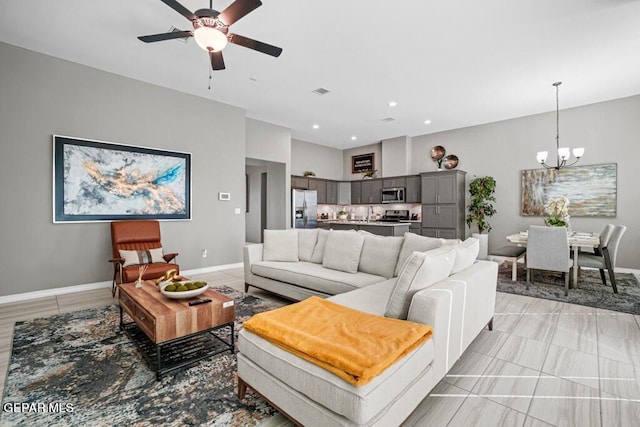 living room featuring ceiling fan with notable chandelier