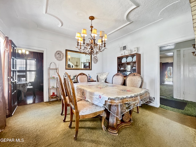 carpeted dining room featuring a notable chandelier and a textured ceiling