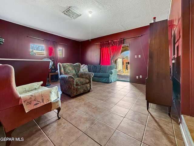 living area with a textured ceiling and light tile floors