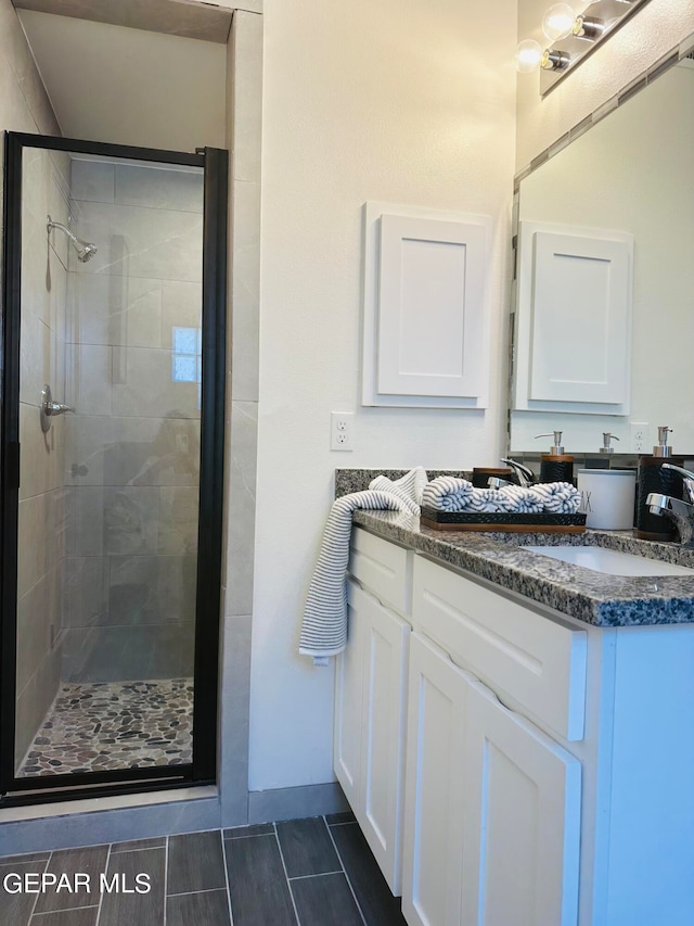 bathroom with tile flooring, vanity, and an enclosed shower