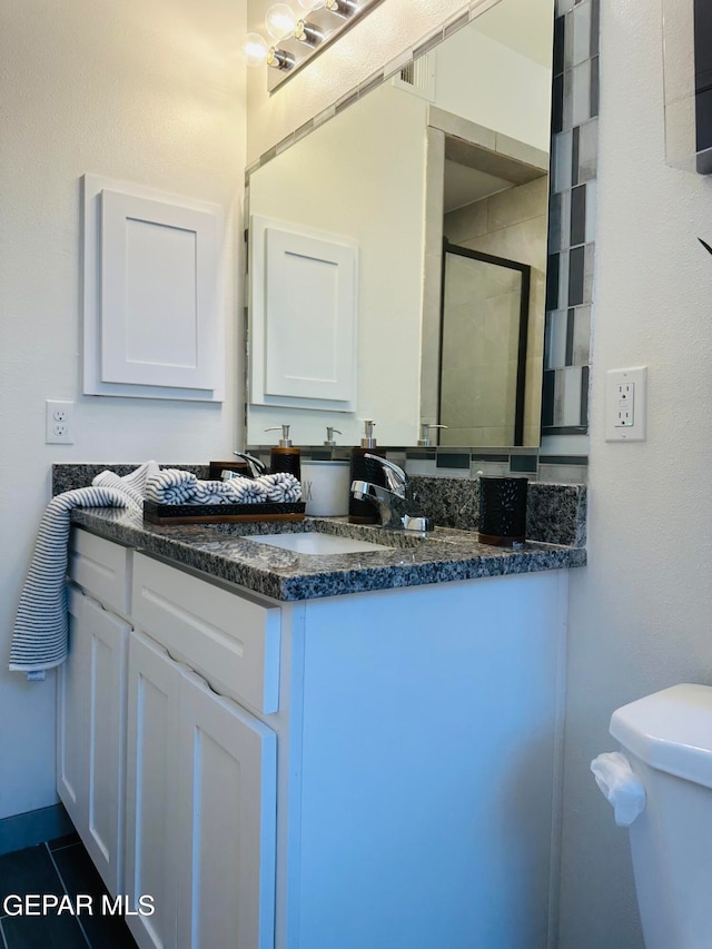 bathroom with toilet, tile floors, and vanity with extensive cabinet space