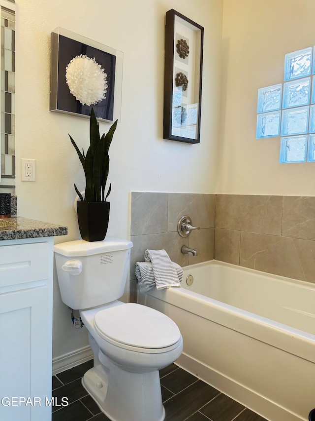 bathroom featuring toilet, vanity, and tile flooring