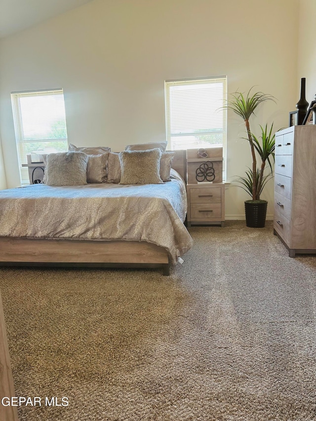 carpeted bedroom featuring vaulted ceiling and multiple windows