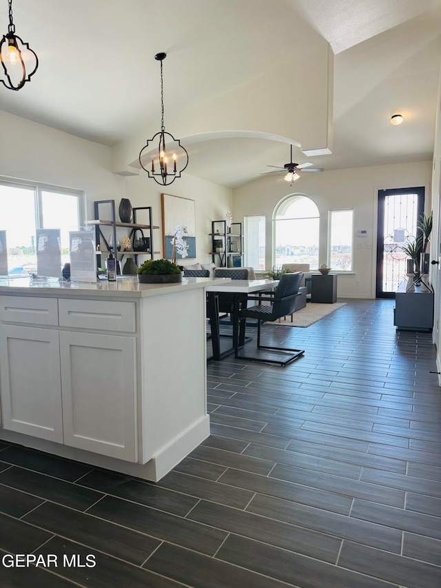 kitchen featuring decorative light fixtures, plenty of natural light, white cabinetry, and ceiling fan with notable chandelier