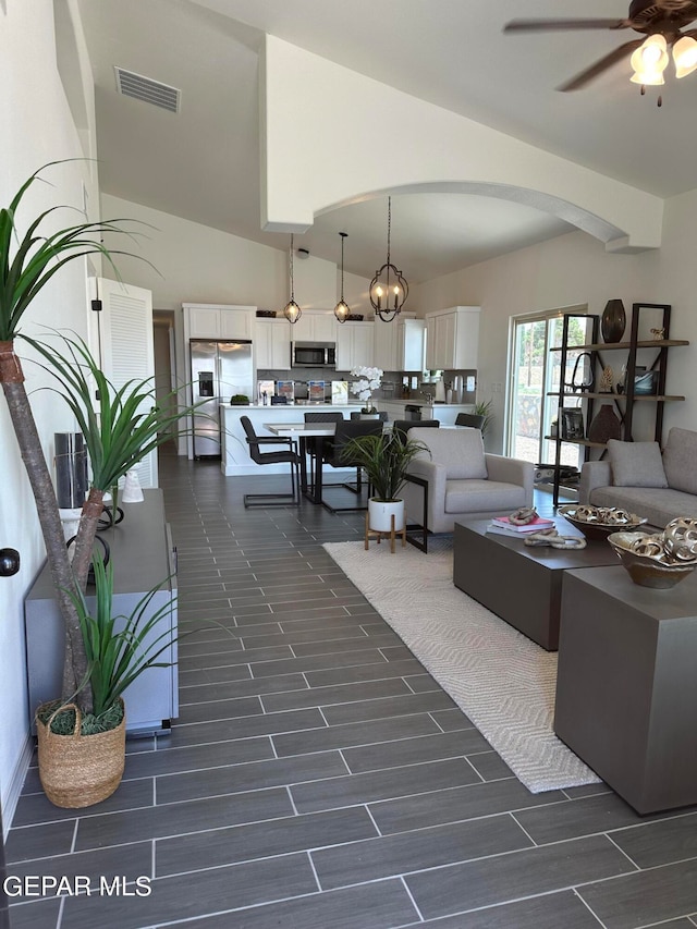 living room with ceiling fan with notable chandelier