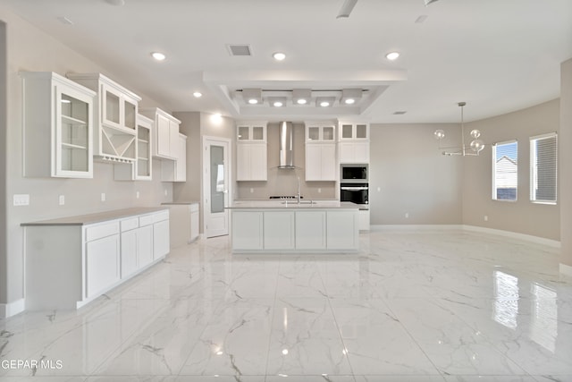 kitchen featuring marble finish floor, appliances with stainless steel finishes, wall chimney range hood, and recessed lighting