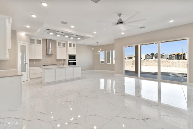 kitchen featuring recessed lighting, marble finish floor, a sink, and wall chimney range hood