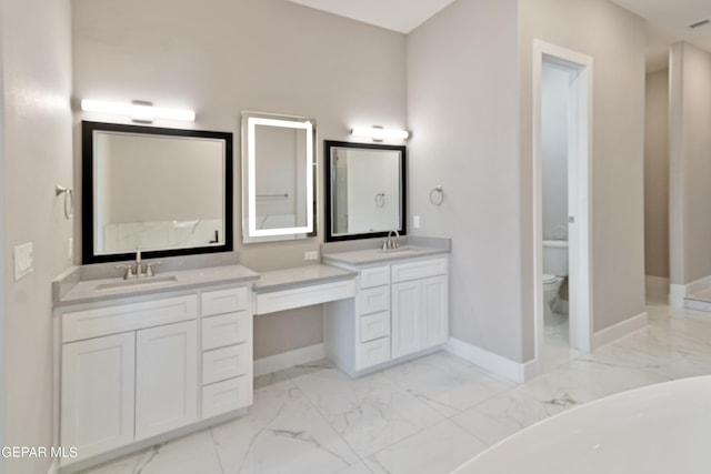 bathroom with toilet, marble finish floor, baseboards, and vanity