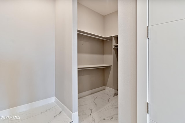 spacious closet featuring marble finish floor