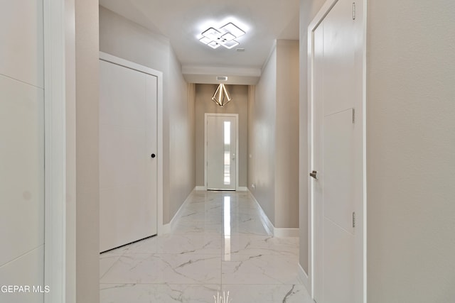 doorway to outside featuring marble finish floor and baseboards