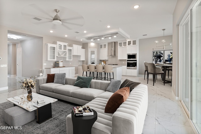 living room with ceiling fan with notable chandelier