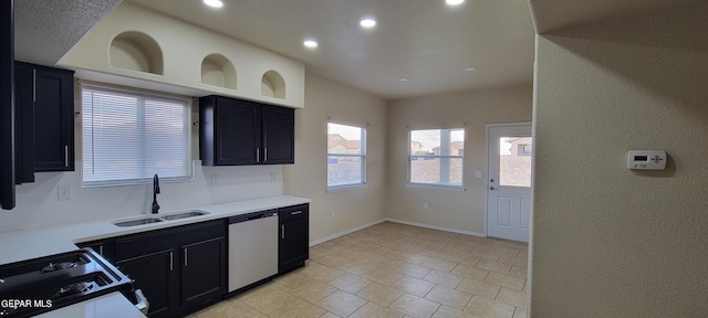 kitchen with stainless steel dishwasher, sink, range, and light tile floors