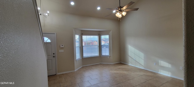 foyer entrance with ceiling fan and light tile flooring