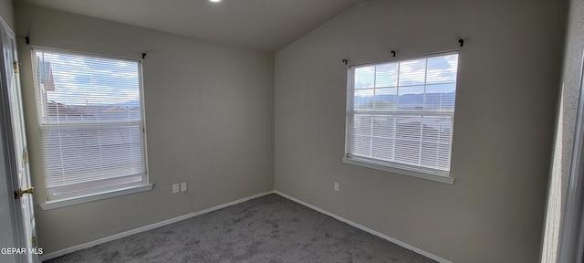 carpeted spare room featuring lofted ceiling