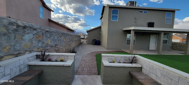 rear view of house with a lawn and a patio