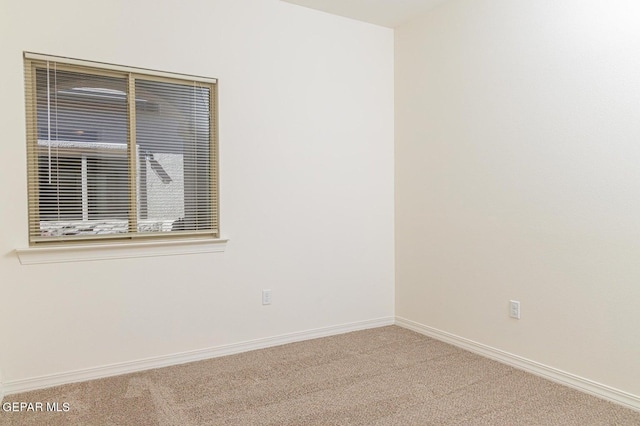 spare room featuring light colored carpet