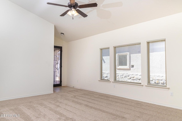 empty room with lofted ceiling, ceiling fan, light carpet, and a healthy amount of sunlight