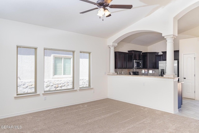 kitchen featuring appliances with stainless steel finishes, light colored carpet, ceiling fan, and lofted ceiling