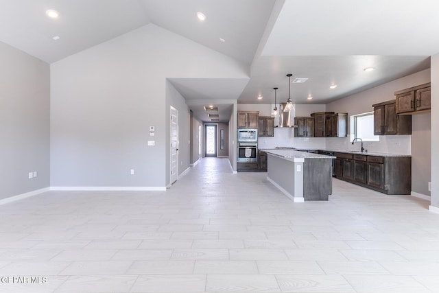 kitchen with open floor plan, a center island, stainless steel appliances, baseboards, and dark brown cabinets