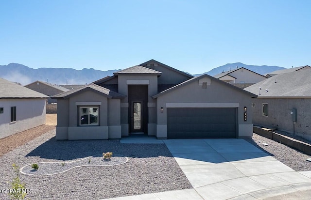 single story home featuring stucco siding, a mountain view, driveway, and a garage